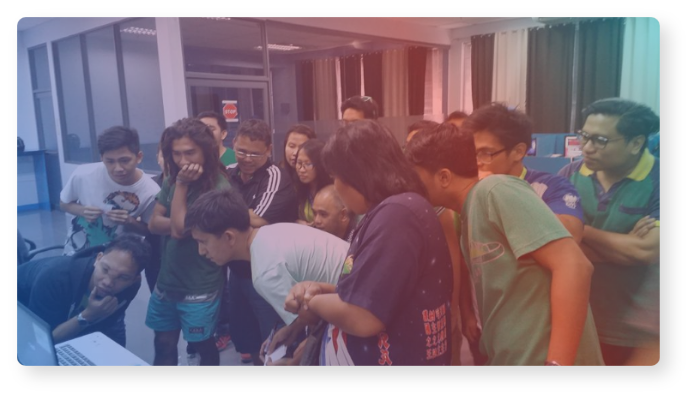 Multiple people huddled in front of a computer.